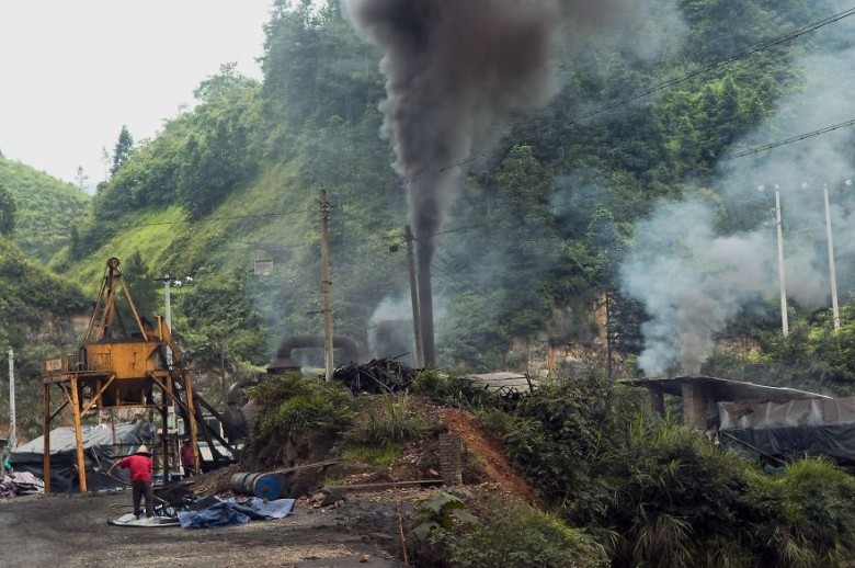 Factory emissions against a backdrop of lush greenery