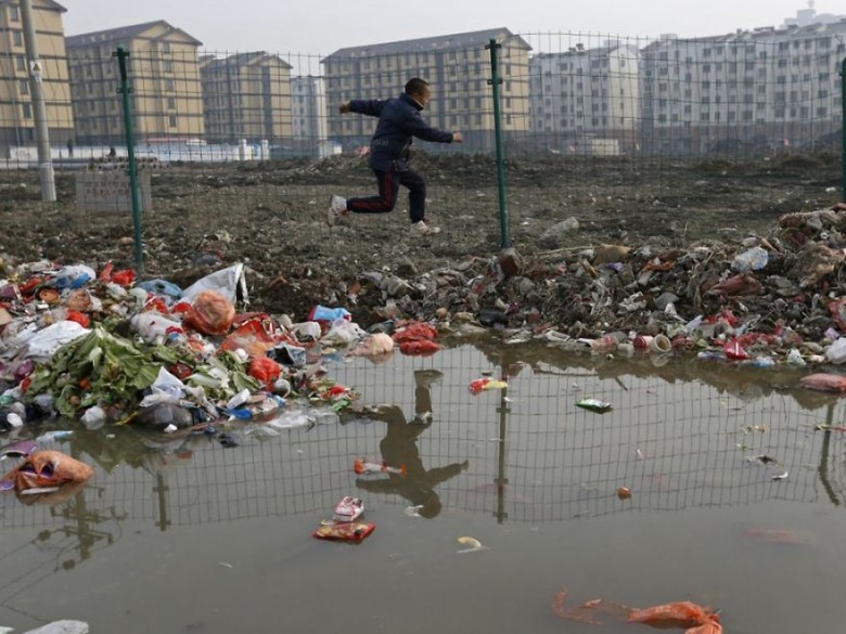 Child playing in the trash at a village, Jiaxing