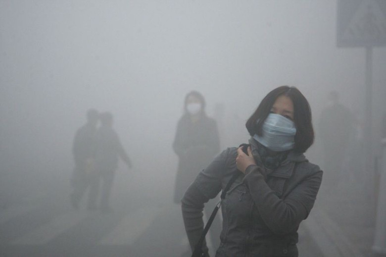 Girl walks through smog in Beijing, where small-particle pollution is 40 times over international safety standard