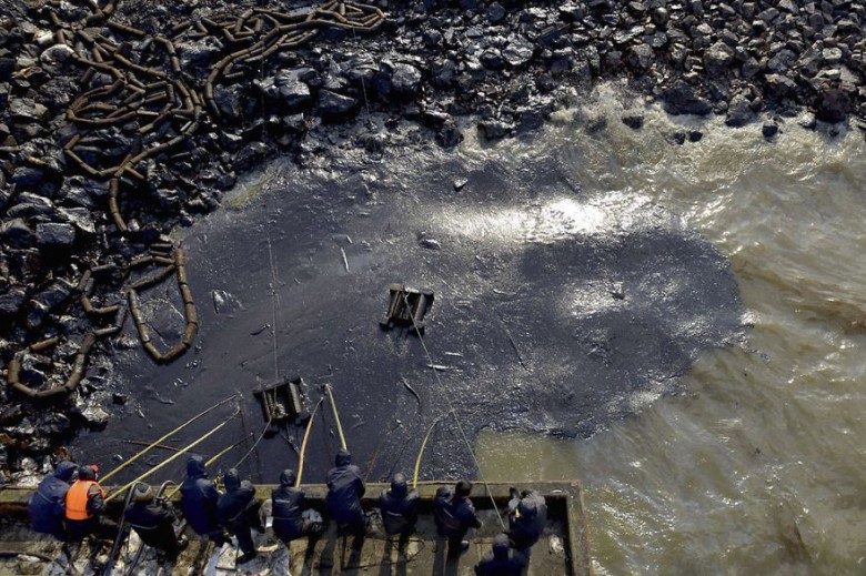 Workers clean up leaked oil after an oil pipeline explosion, Qingdao, Shandong